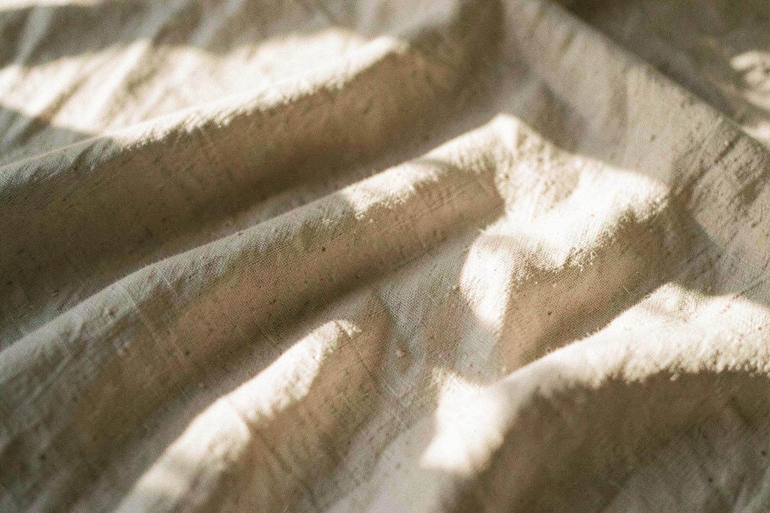 Sunlight falling across folded linen